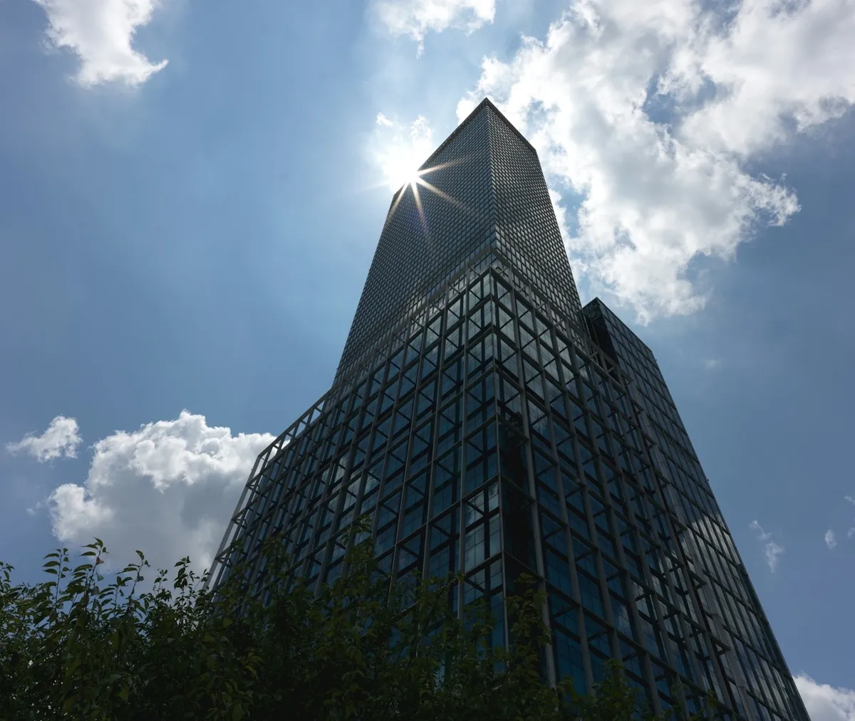 Immeuble de bureaux tout en verre en contre-plongée sous un soleil éclatant