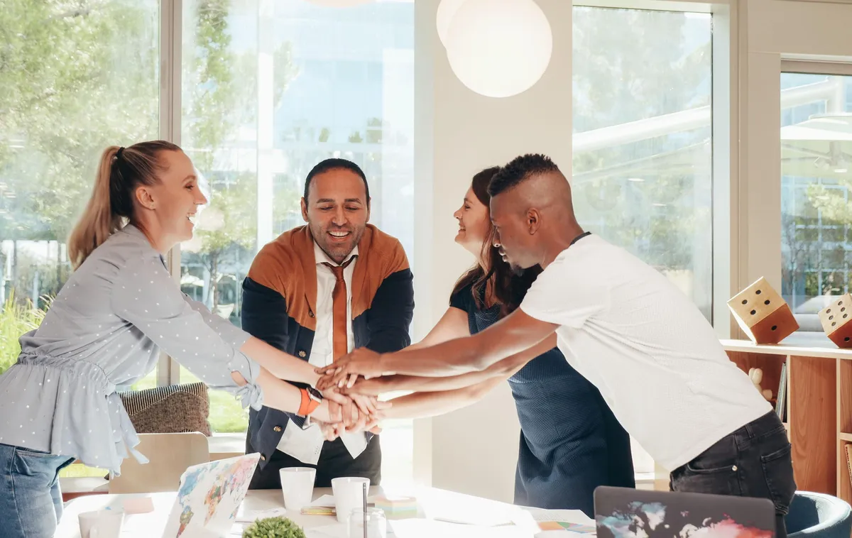 Équipe réunissant ses mains en signe de collaboration