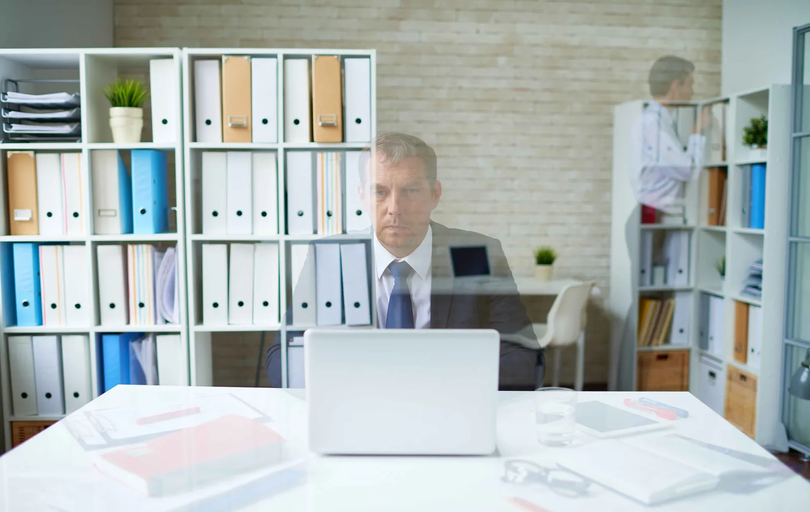 Un directeur de l'environnement de travail concentré à son bureau, dans des locaux parfaitement organisés