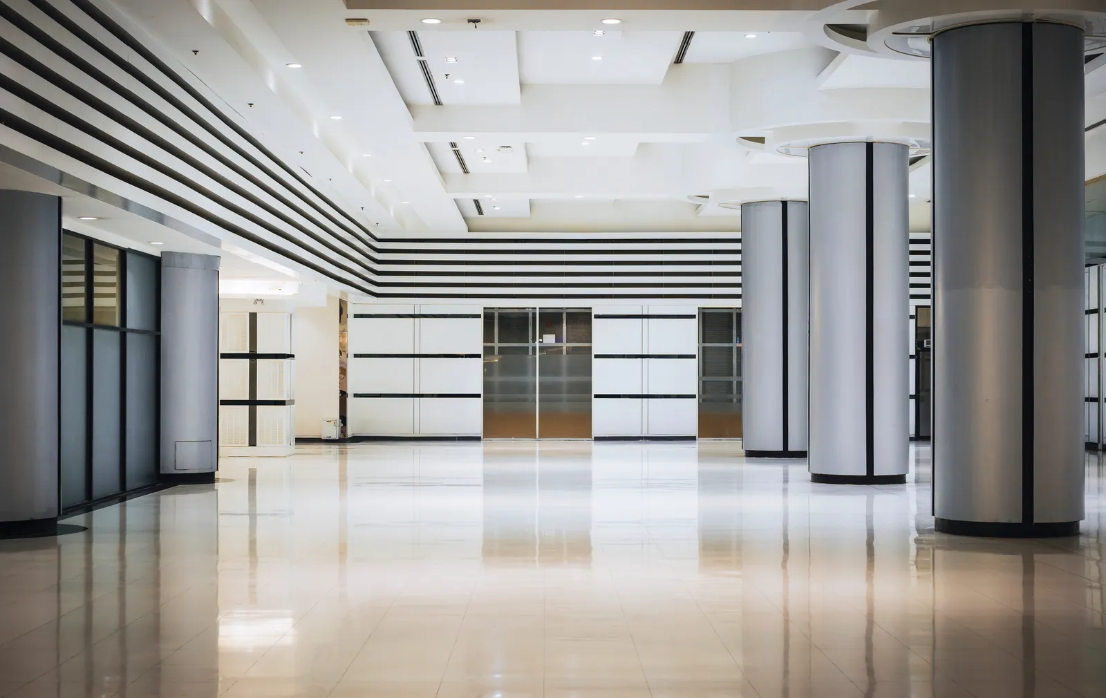 Hall d’accueil d’un immeuble de bureaux tertiaire, sol brillant après le passage des équipes de propreté