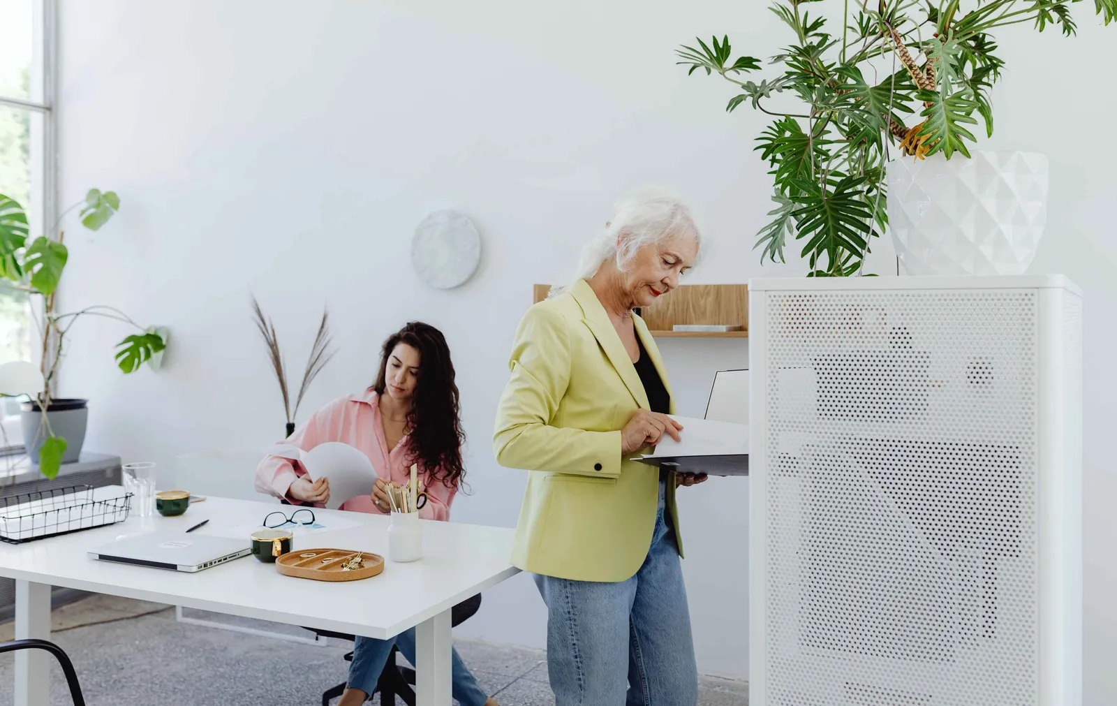 Bureau lumineux avec purificateur d'air et plantes, deux collaboratrices dans un environnement de travail sain