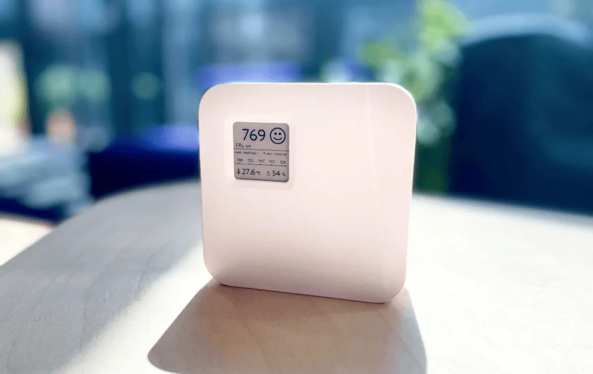 Capteur de qualité de l'air posé sur un bureau affichant 769 ppm de CO₂, la température et l'humidité